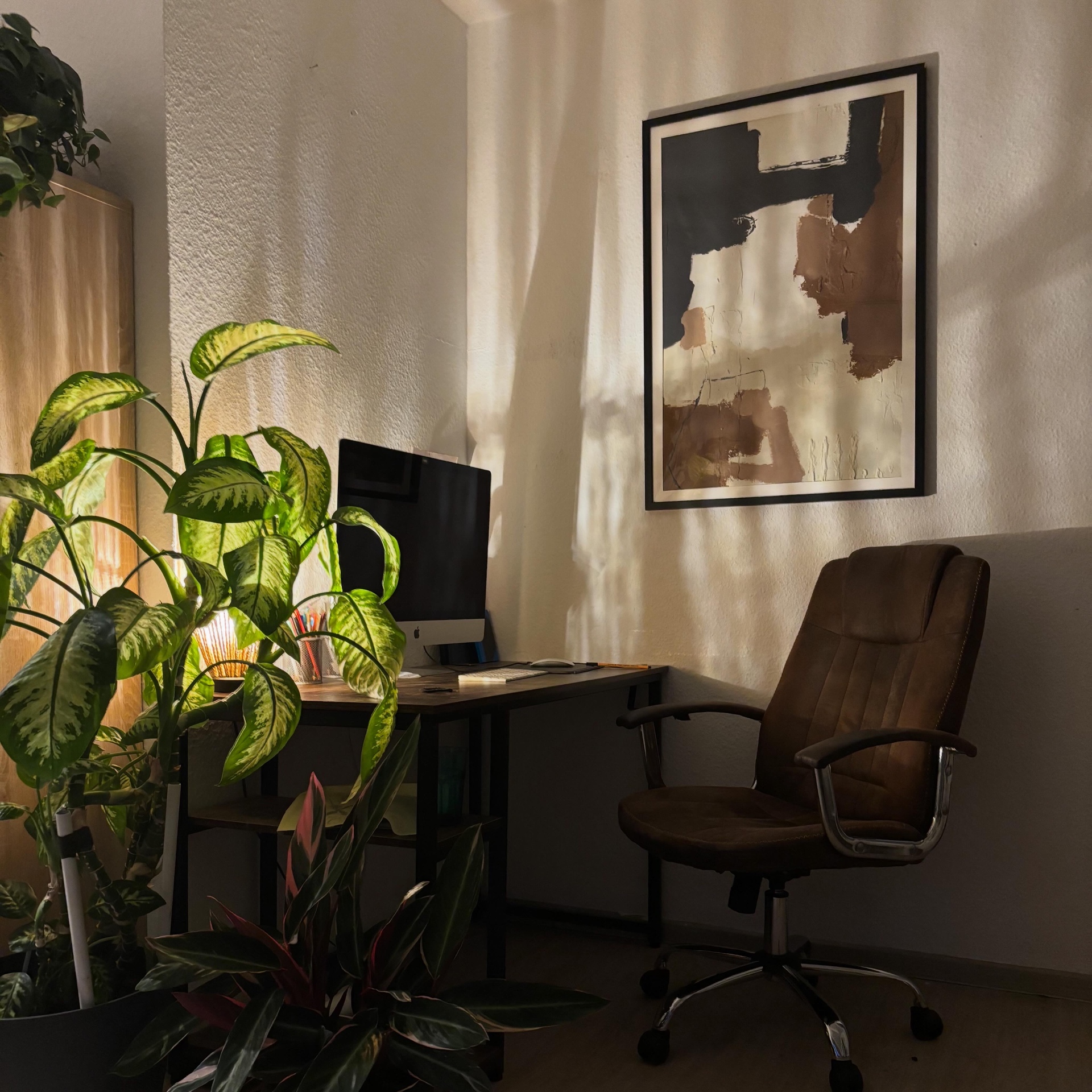 Erdige, abstrakte Arbeit über einem Schreibtisch im Abendlicht