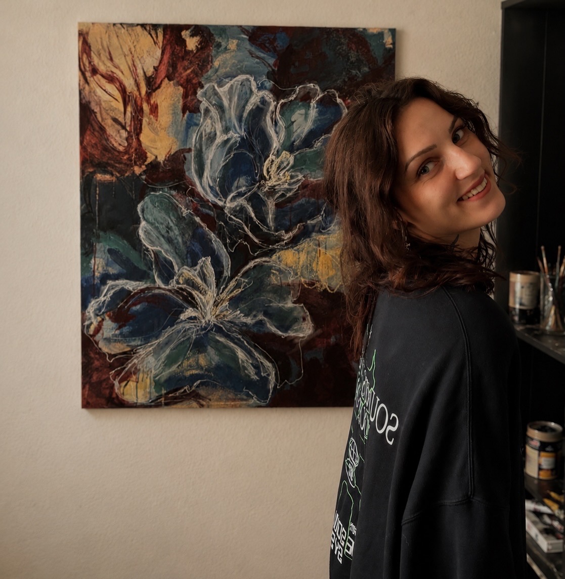 Lena Evelyn Krieger im Atelier vor dem Werk Inneres Blumenpflücken