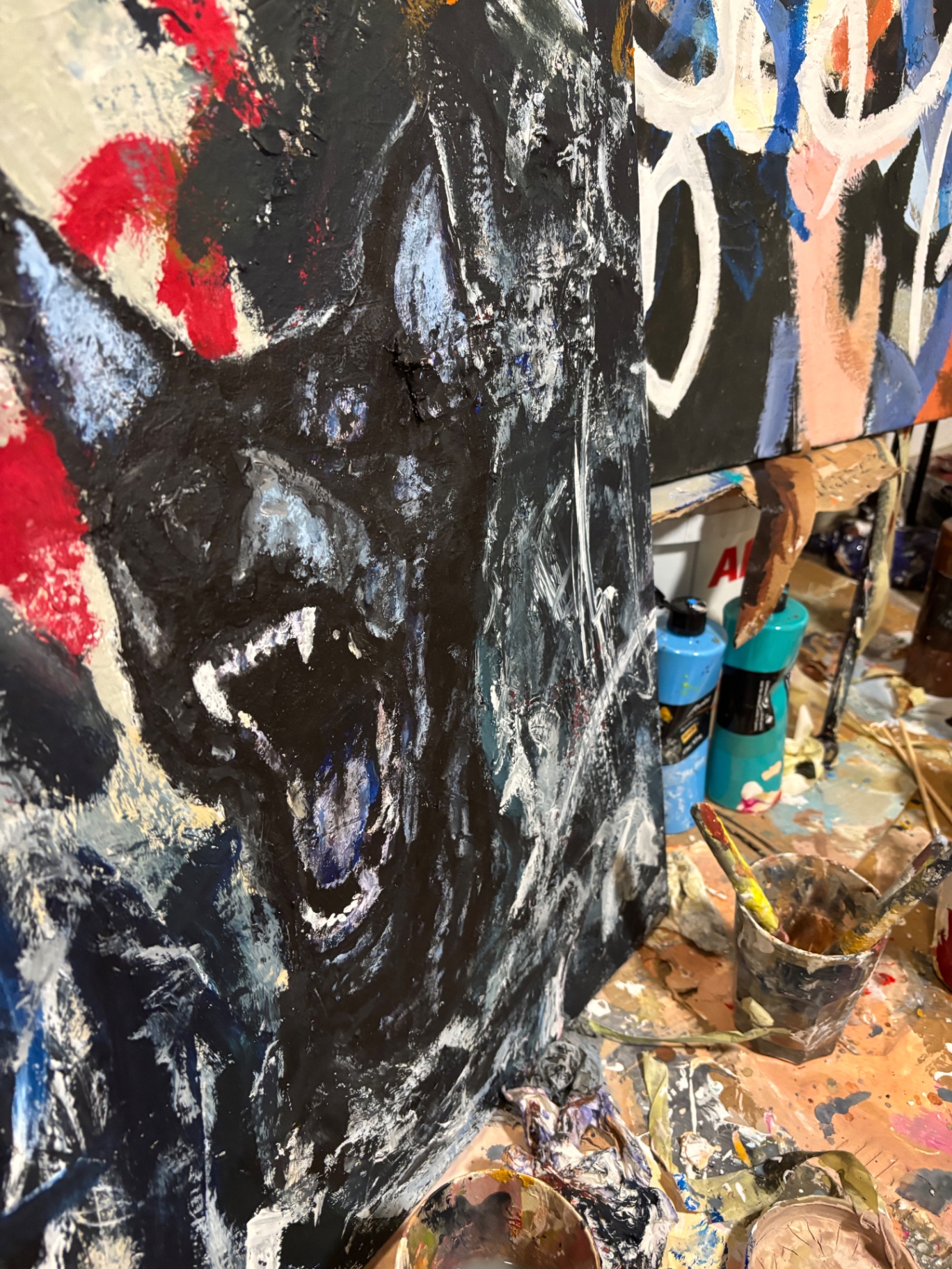 Detail einer Arbeit in Entstehung — dichte schwarze Schichten mit blauen und roten Einschlüssen